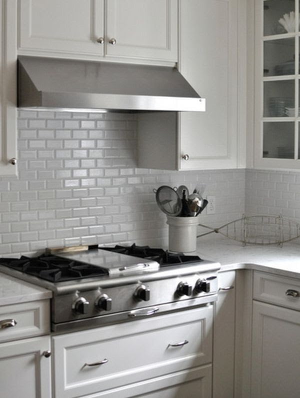 A traditional kitchen showcasing a white backsplash and matching cabinets