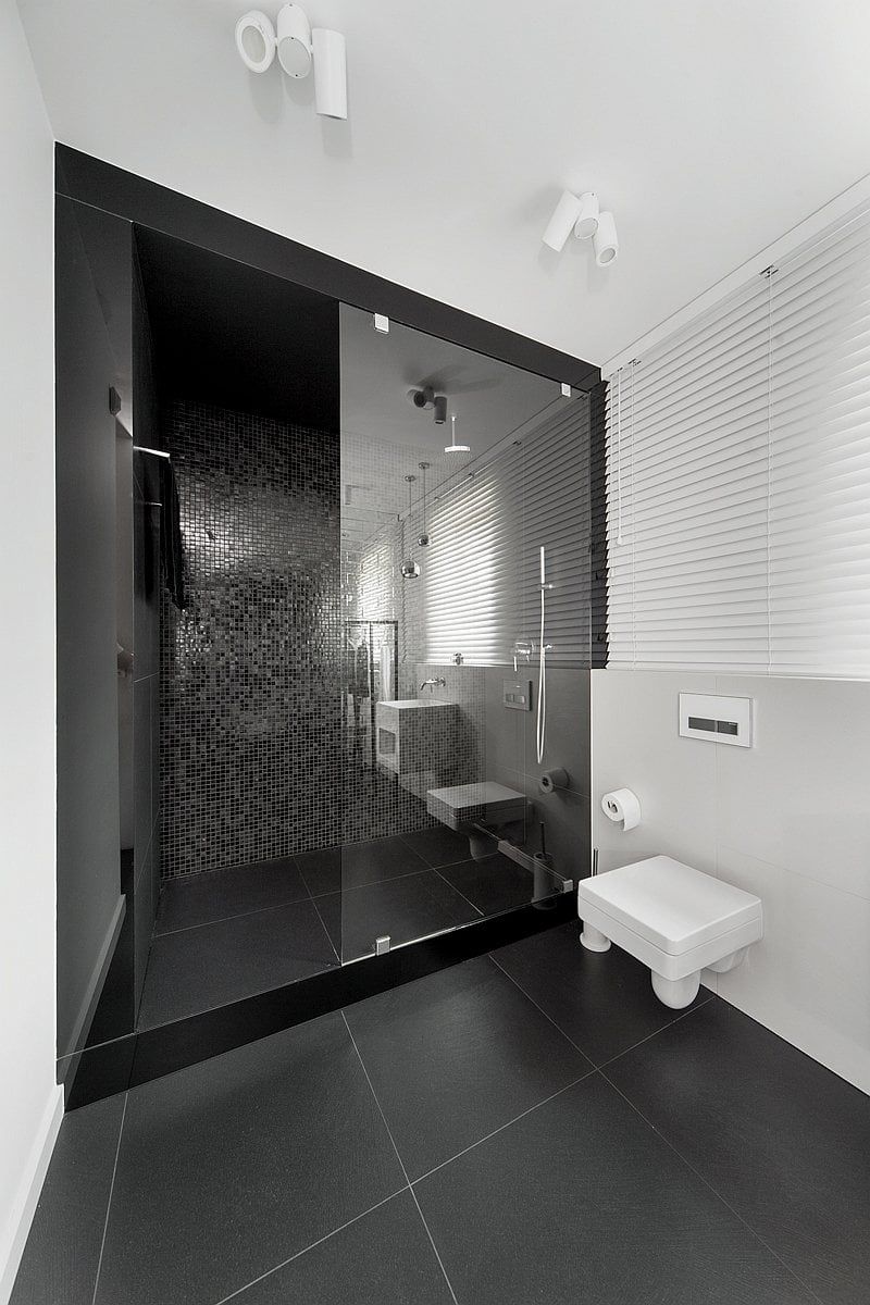 black and white bathroom is in a home in Mikolów, Poland, designed by Widawscy Studio Architektury