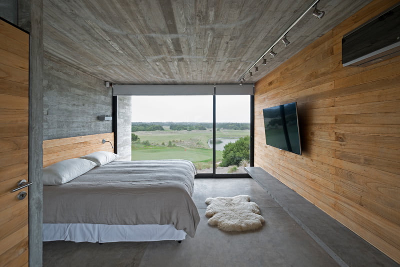exposed concrete modern house master bed with golf view